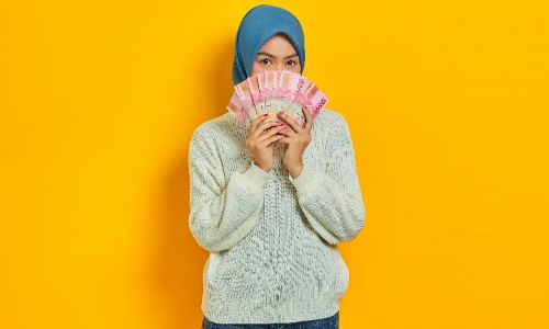 a women cover her face with money